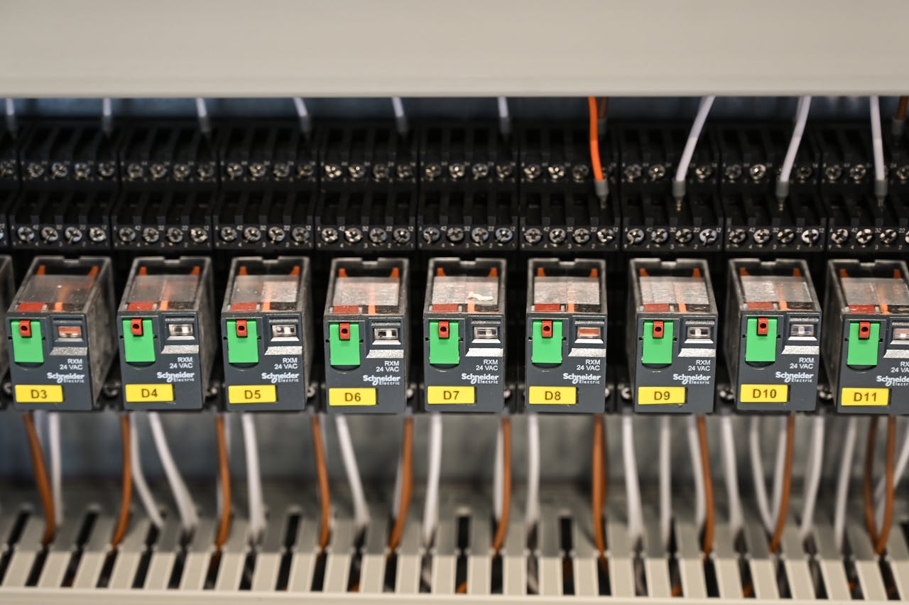 who-we-are Close-up view of electrical relays in an industrial panel box showcasing circuit components.