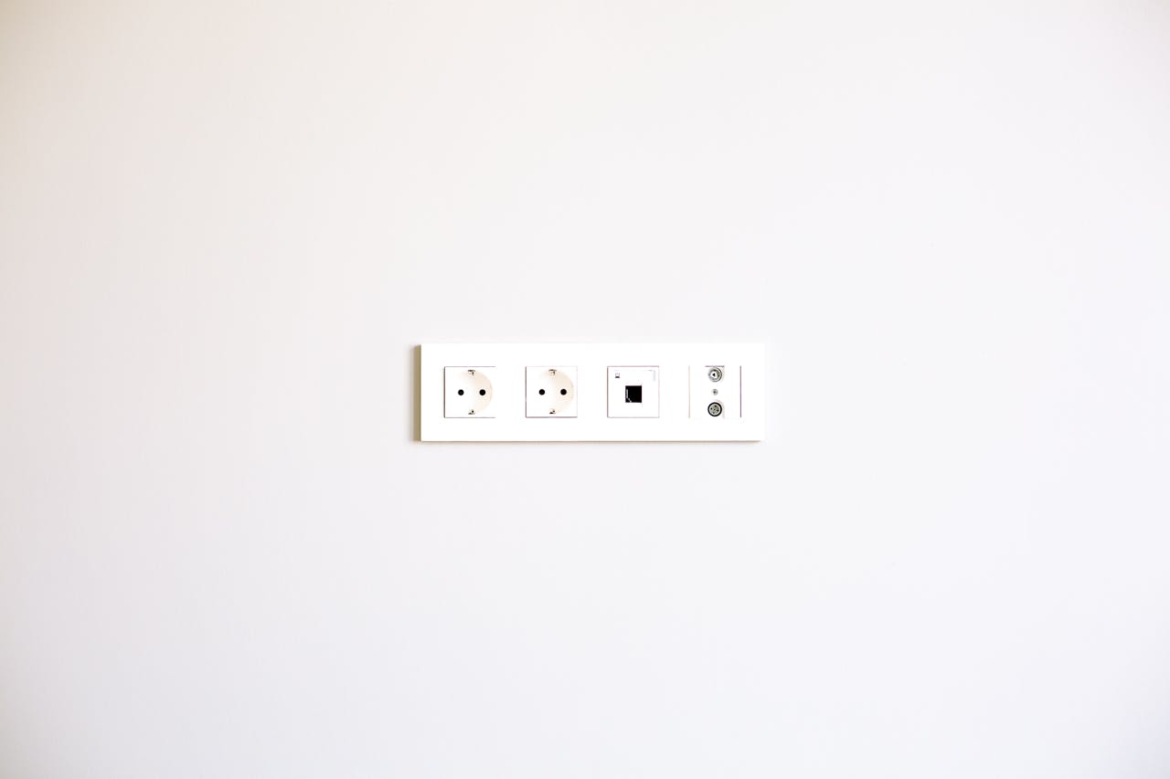 services-03 A minimalist image showcasing a modern wall outlet array on a bright white wall.